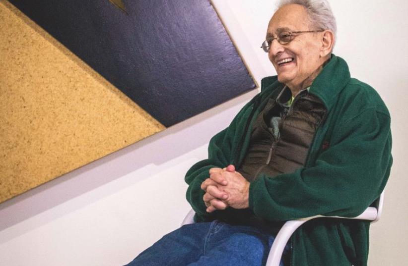 Frank Stella sits in front of his ‘Łunna Wola II’ (1973) at the ‘Frank Stella and Synagogues of Historic Poland’ exhibition at the POLIN Museum of the History of Polish Jews in Warsaw (photo credit: MAGDA STAROWIEYSKA / COURTESY POLIN MUSEUM)