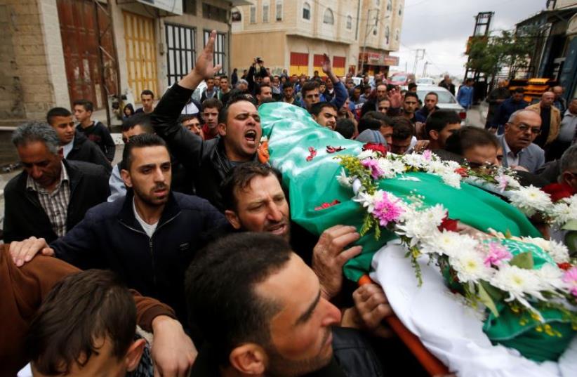 Palestinians hold the funeral for a man shot dead by Israeli forces after an attack on a soldier on March 24 in the West Bank city of Hebron (photo credit: REUTERS)