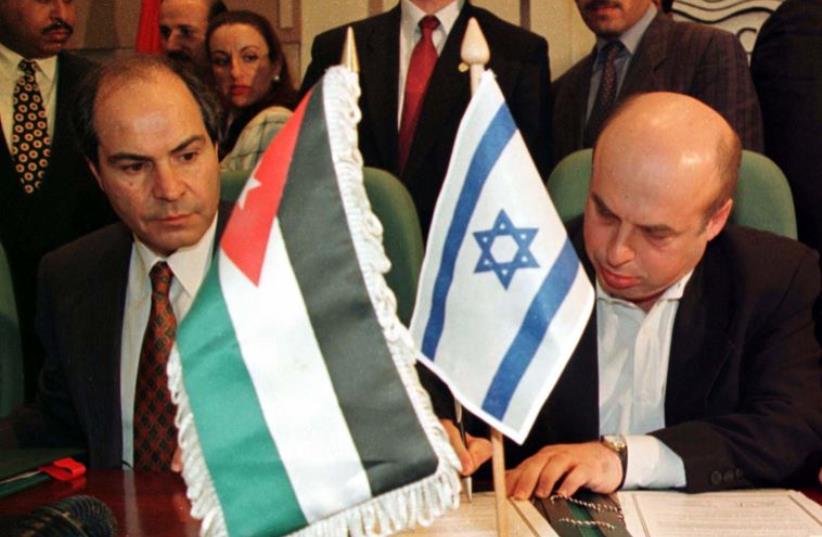 Israeli Trade Minister Natan Sharansky (R) signs an agreement to expand economic ties with Jordan while his Jordanian counterpart Hani Mulqi watches, 1998 (photo credit: REUTERS)