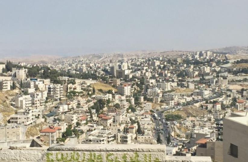 A VIEW from a-Tur of Arab neighborhoods in east Jerusalem, with Abu Dis, beyond the security barrier, in the distance. (photo credit: SETH J. FRANTZMAN)