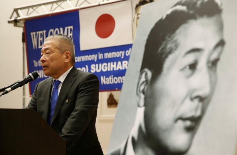 Nobuki Sugihara, son of Japanese diplomat, Chiune Sugihara (depicted in black and white picture), who helped saved thousands of Lithuanian Jews in World War 2, speaks during a street-naming ceremony in honor of his father in Netanya, Israel June 7, 2016 (photo credit: REUTERS)