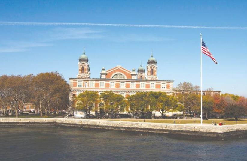 A US FLAG flies in front of the Ellis Island Immigration Museum in New York, October 2013 (photo credit: LUCAS JACKSON / REUTERS)