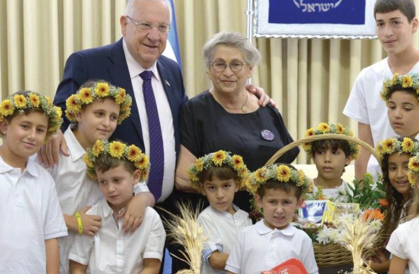 PRESIDENT REUVEN RIVLIN and his wife, Nechama, welcome the children of dairy farmers at the President’s Residence in Jerusalem yesterday. (photo credit: Mark Neiman/GPO)
