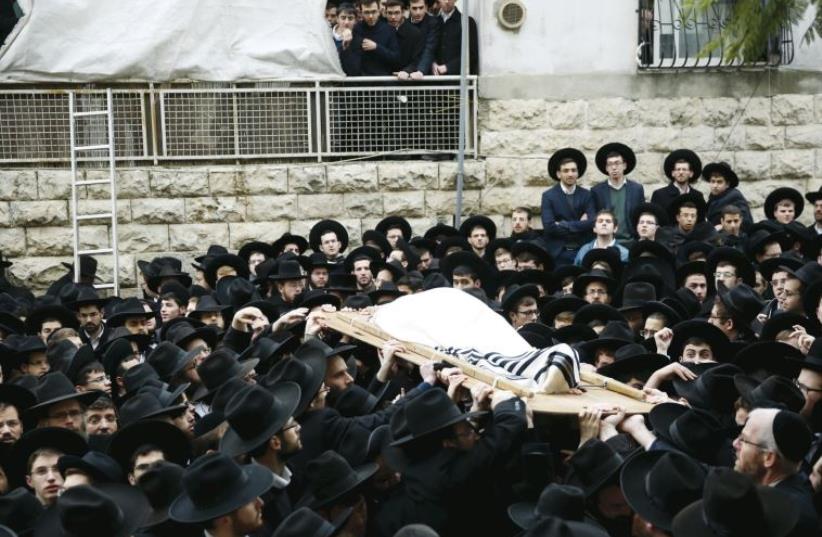 Ultra-orthodox men in Mea She’arim carry the body of Rabbi Raphael Shmuelevich, head of the Mir Yeshiva, at his funeral in January (photo credit: REUTERS)