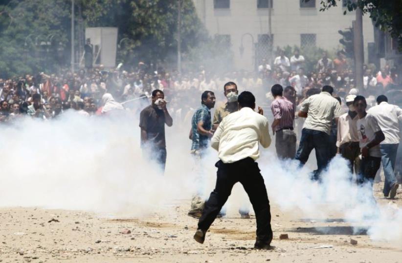 Protesters run away from tear gas in Tahrir Square in Cairo in June 2011 (photo credit: REUTERS)