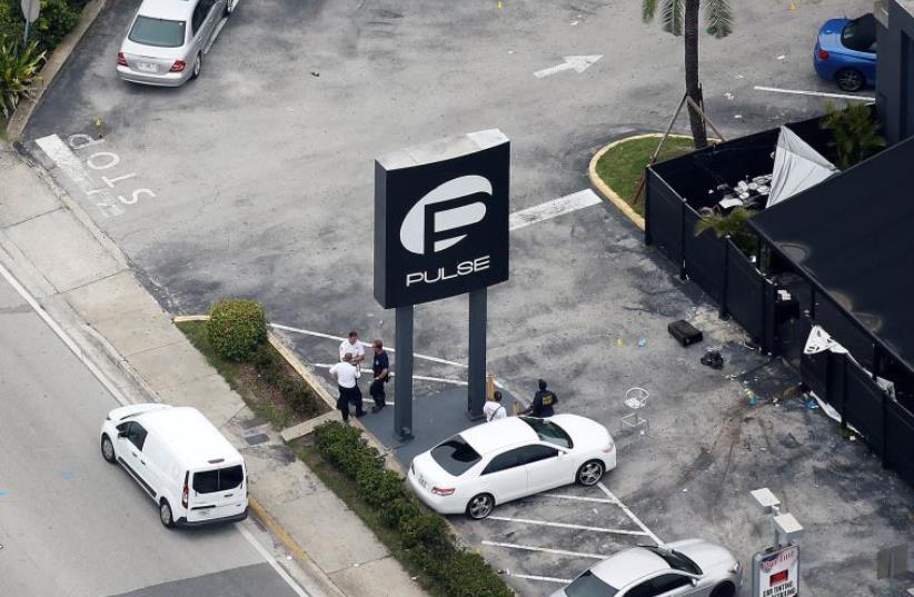 Investigators work the scene following a mass shooting at the Pulse gay nightclub in Orlando Florida, U.S. June 12, 2016. (photo credit: REUTERS)