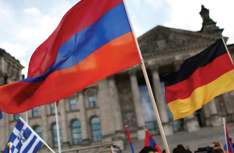 SUPPORTERS WAVE Armenian and German flags earlier this month in front of the Reichstag, as they protest in favor of the resolution that declares the 1915 massacre of Armenians by Ottoman forces a ‘genocide (photo credit: HANNIBAL HANSCHKE/REUTERS)