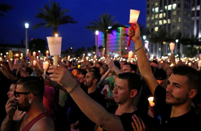 People gather for a candlelight vigil during a memorial service for the victims of the shooting at the Pulse gay nightclub in Orlando, Florida, June 13, 2016 (photo credit: REUTERS)