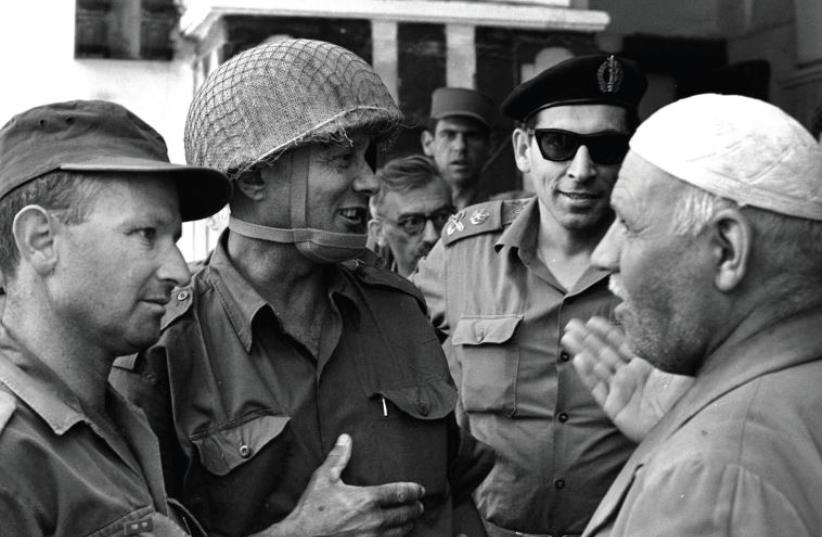 Former defense minister Moshe Dayan, (center), and Gen. Rehavam Ze'evi, (2nd left), in conversation with the Palestinian keeper of the Cave of the Patriarchs in Hebron during the Six Day War (photo credit: AFP PHOTO)