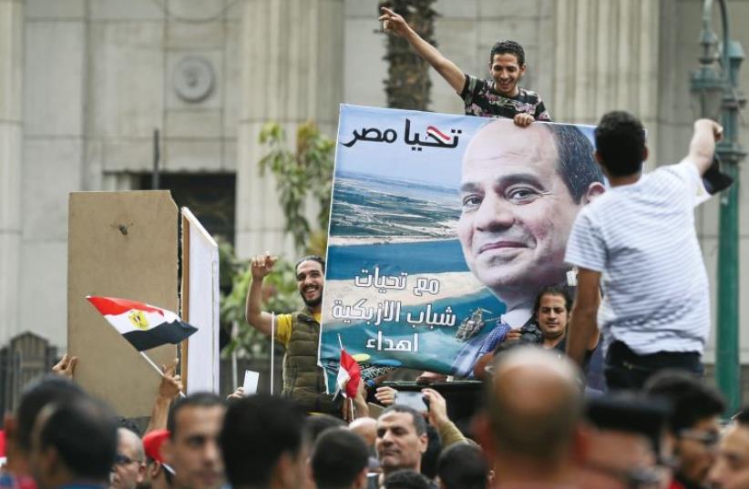 Pro-government protesters hold a poster of Egyptian President Abdel Fattah al-Sisi and shout slogans against journalists in front of the Syndicate of Journalists, in Cairo, on May 4 (photo credit: REUTERS)