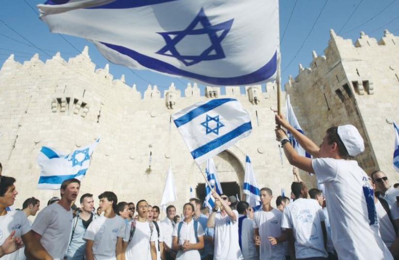Young people wave Israeli flags during the Jerusalem Day march on June 5 (photo credit: MARC ISRAEL SELLEM)