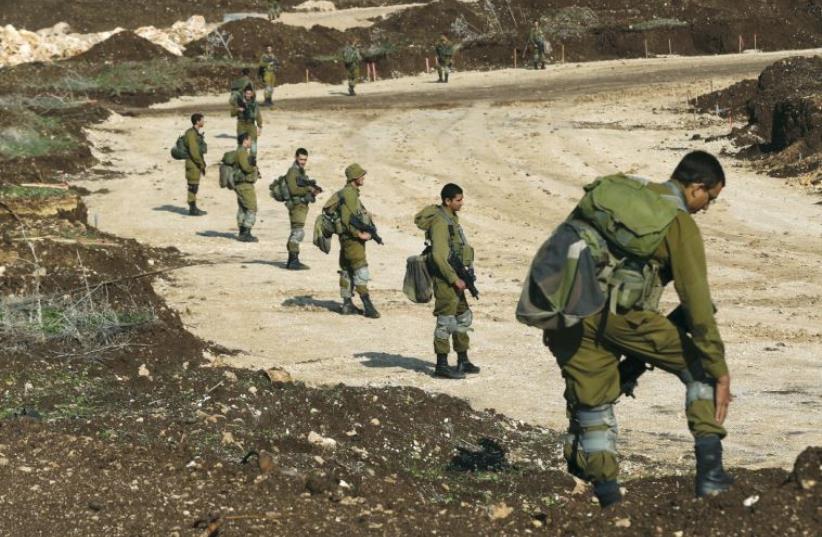 IDF soldiers search for remains of rockets fired from Lebanon in December 2015 (photo credit: REUTERS)