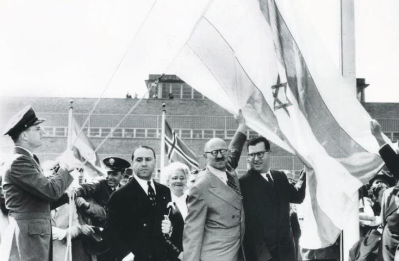 Abba Eban (center right), and David Hacohen (center left) raise the Israeli flag above the UN building on November 29, 1947, soon after the UN voted to partition Palestine (photo credit: REUTERS)