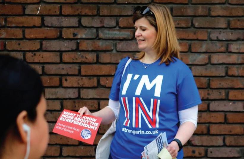 A WOMAN hands out leaflets last month, campaigning to stay in Europe for the Brexit vote, in London. (photo credit: REUTERS)
