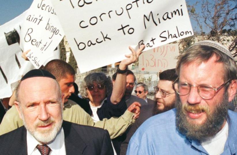 PEOPLE PROTEST against US philanthropist Irving Moskowitz (left) as he visits a Jewish resident in Ras al-Amud, Jerusalem, in 1999 (photo credit: REUTERS)