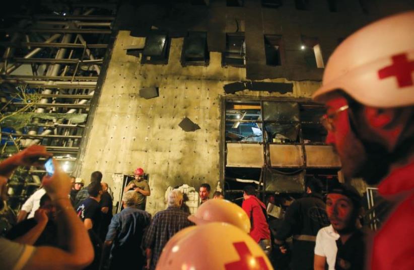 Red Cross members work at the site of an explosion at Blom Bank in Beirut, June 12 (photo credit: REUTERS)