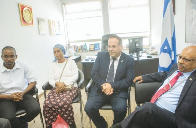 DEPUTY MINISTER for Regional Cooperation Ayoub Kara (center) and Ethiopian Ambassador Helawe Yosef (right) meet with the family of Avraham Mengistu at the Knesset on Monday. (photo credit: MIRIAM ALSTER/FLASH90)