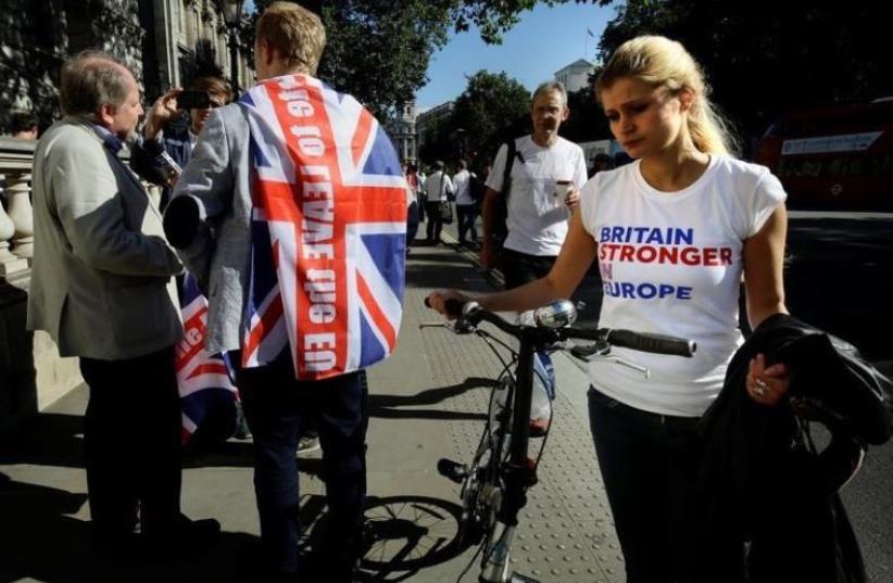 A vote remain supporter walks past a vote leave supporter outside Downing Street after Britain voted to leave the European Union. (photo credit: REUTERS)