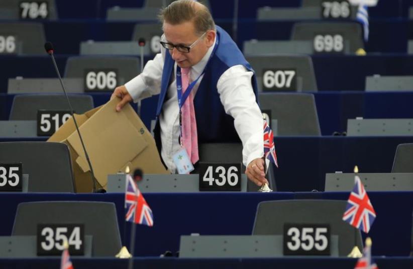 WILL THESE have to all be taken down now? Raymond Finch, member of the United Kingdom Independence Party (UKIP) and member of the European Parliament puts British Union Jack flags on the desks of his fellow members of the Europe of Freedom and Direct Democracy Group of the European Parliament, ahead (photo credit: REUTERS)