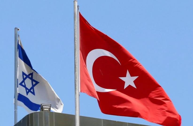 A Turkish flag flutters atop the Turkish embassy as an Israeli flag is seen nearby, in Tel Aviv, Israel June 26, 2016 (photo credit: REUTERS)