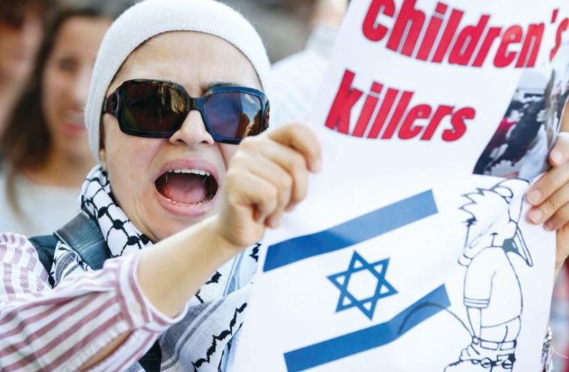 A PROTESTER holds up a placard during a demonstration in Stockholm against Israel, in July 2014. (photo credit: REUTERS)