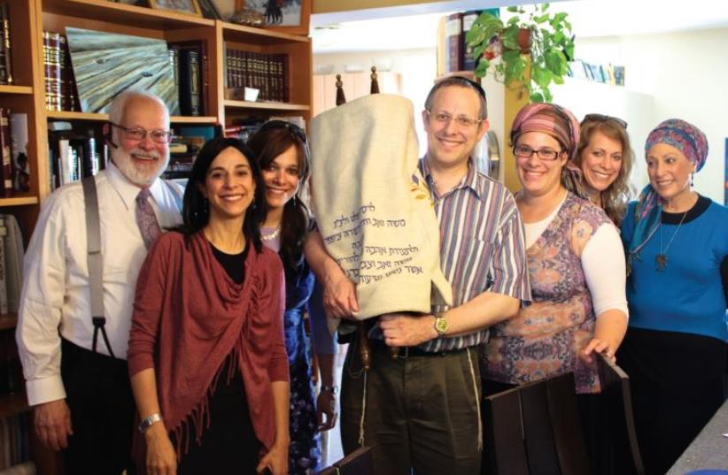 The family triumphantly flanks the Torah: (from left) Marty Ginsberg, Hindy Bryks, Amy Gottlieb, Steven Ginsberg, Hudi Kenigsberg, writer Laura Ben-David and Carol Ginsberg (photo credit: LAWRENCE BEN-DAVID)