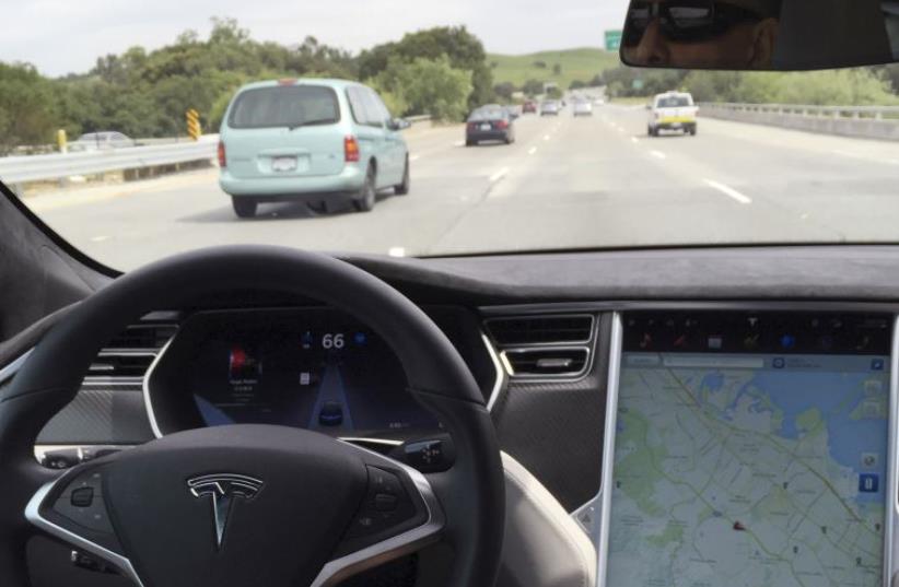 The interior of a Tesla Model S is shown in autopilot mode in San Francisco, California, U.S., April 7, 2016. (photo credit: REUTERS)