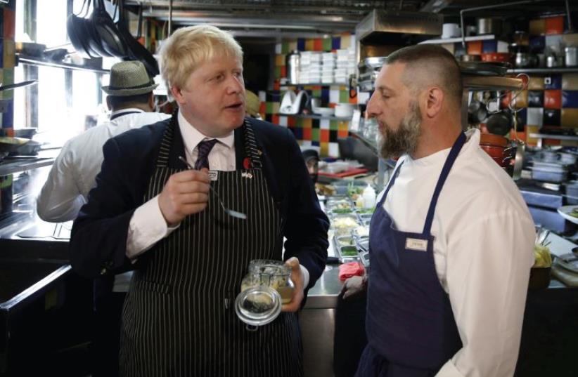 Former London mayor and Brexit champion Boris Johnson stands beside chef Assaf Granit, during a visit to the Machneyuda restaurant in Jerusalem in November (photo credit: REUTERS)