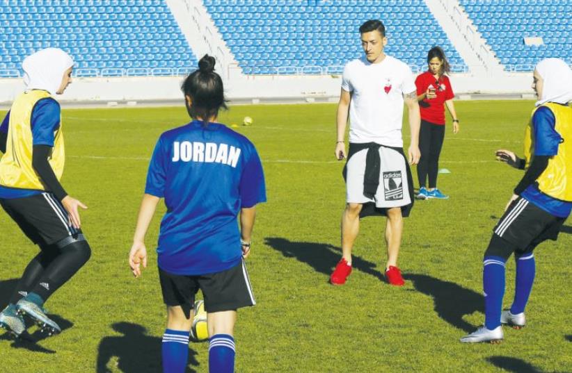 Jordanian U-17 women soccer players train with German footballer Mesut Ozil, during a training session at Amman International Stadium, in May (photo credit: REUTERS)