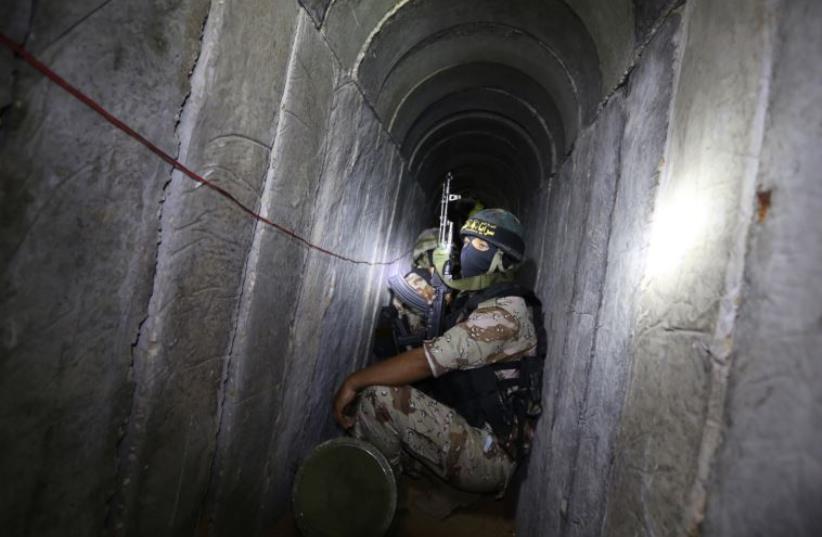 Palestinian militants from the Islamic Jihad's armed wing, the Al-Quds Brigades, in a tunnel in the south of the Gaza Strip  (photo credit: MAHMUD HAMS / AFP)