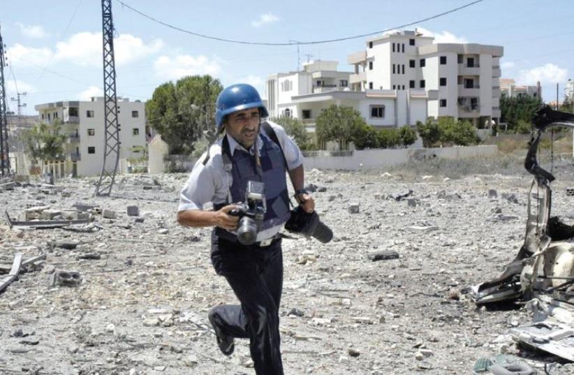 A LEBANESE NEWS PHOTOGRAPHER runs for cover upon hearing Israeli jets above the village of Kfarjouz in 2006. (photo credit: KAMEL JABER/REUTERS)