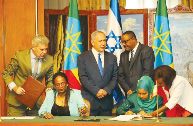 Prime Minister Benjamin Netanyahu and Ethiopian Prime Minister Hailemariam Desalegn preside over the signing of mutual agreements between Israel and Ethiopia, with Israeli Ambassador to Ethiopia Belaynesh Zevadia (seated left) (photo credit: FOREIGN MINISTRY)