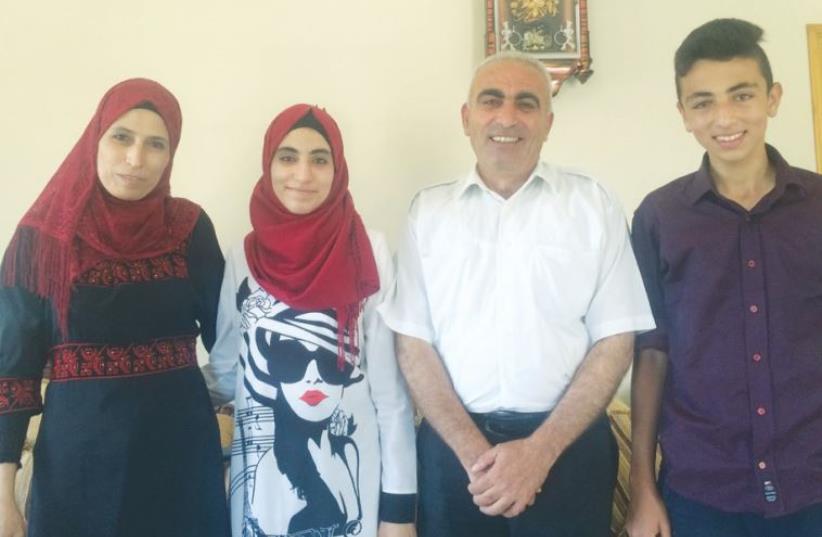 RAHAF MUFEED ABDULLAH (second left), who received the highest score on the Palestinian national standardized test, poses for a photo with her family. (photo credit: ADAM RASGON)