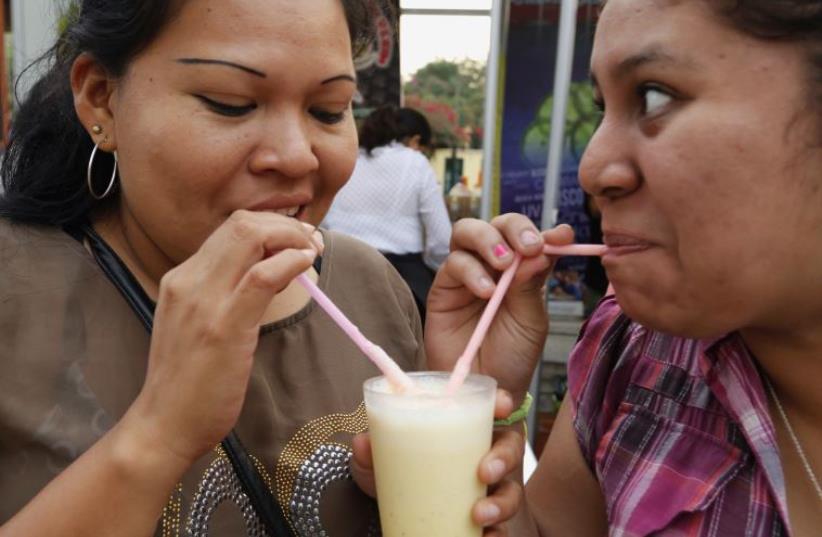 People drink traditional Peruvian Pisco Sour during a Pisco Sour festival in Lima (photo credit: MARIANA BAZO/REUTERS)