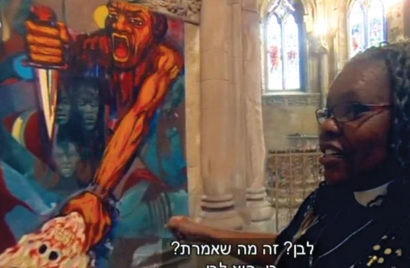PASTOR RENEE MCKENZIE explains a mural in the Church of the Advocate in Philadelphia to Channel 10’s Nadav Eyal (not seen). (photo credit: screenshot)