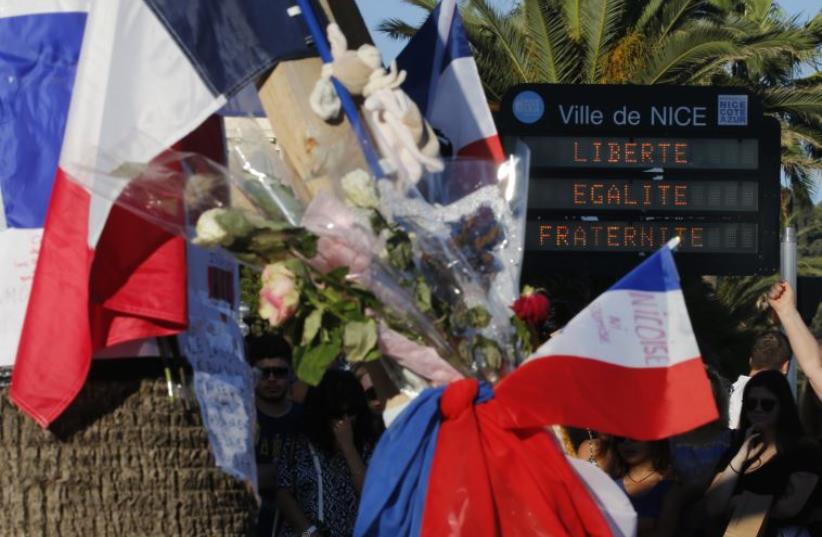 Flowers and flags placed in tribute to victims of the deadly truck attack in Nice, France on Bastille Day  (photo credit: REUTERS)