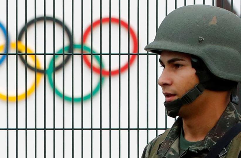 A Brazilian military police soldier patrols at the security fence outside the 2016 Rio Olympics Park in Rio de Janeiro, Brazil, July 21, 2016 (photo credit: REUTERS)