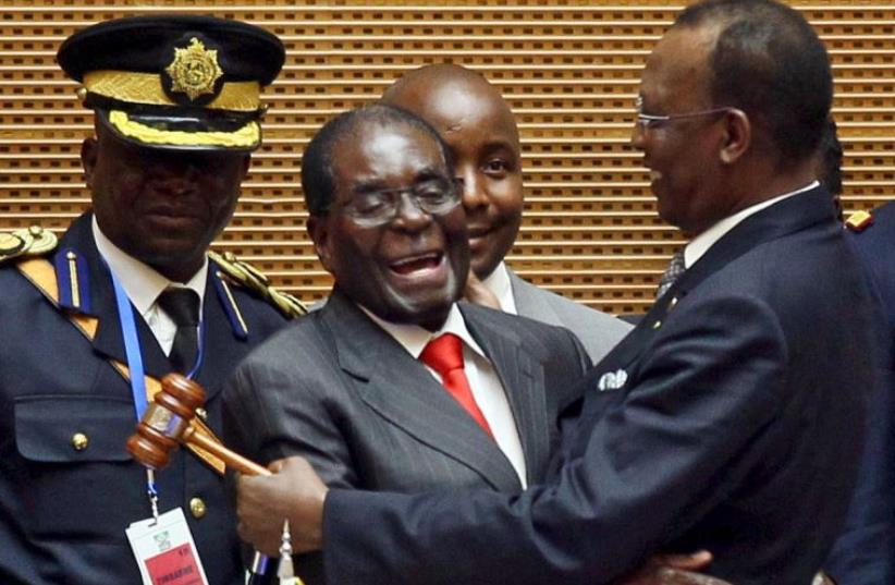 Zimbabwe's President Robert Mugabe (C) talks to Chad's President Idriss Deby (R) after the opening ceremony of the 26th Ordinary Session of the Assembly of the African Union (photo credit: REUTERS)