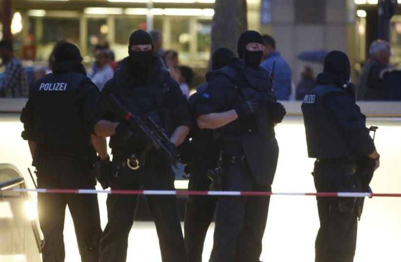 Special force police officers stand guard at an entrance of the main train station, following a shooting rampage at the Olympia shopping mall in Munich (photo credit: REUTERS)