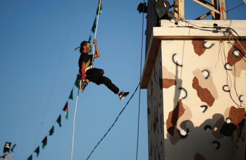 SUMMER FUN in Gaza. A Palestinian rappels down from a building during a Hamas-run summer camp that blends hate and terror education (photo credit: REUTERS)