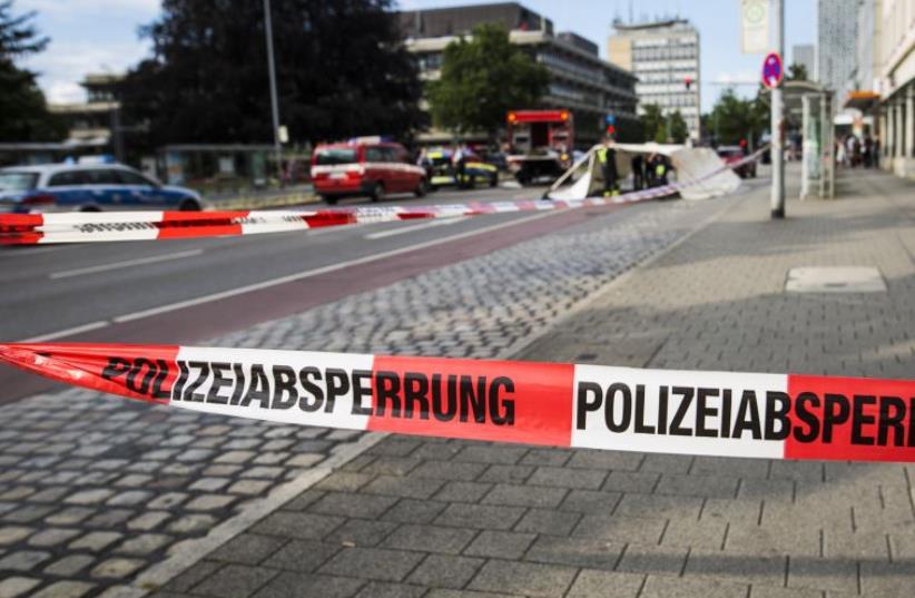 A police line is seen near the site where a Syrian asylum-seeker killed a woman and injured two people with a machete, on July 24, 2016 in Reutlingen, southern Germany. (photo credit: CHRISTOPH SCHMIDT / DPA / AFP)