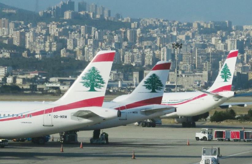 A luggage loading vehicle is driven past Middle East Airlines aircraft at Beirut Airport, Lebanon (photo credit: REUTERS)