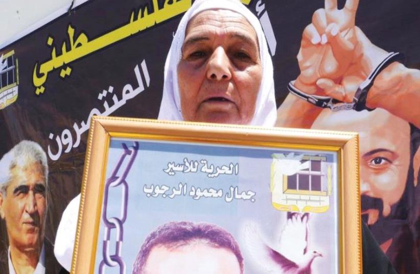 YASMIN RAJOUB displays a photo of her son, Jamal, who is serving a life sentence for terrorism at Rimon Prison. ( (photo credit: JACK BROOK)