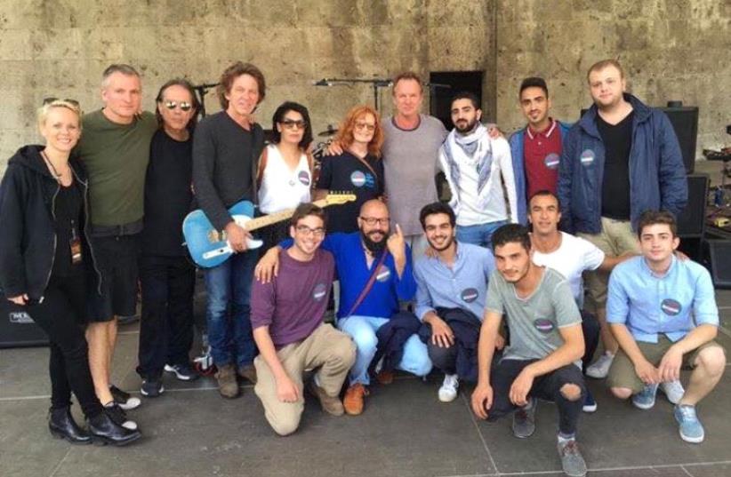Musician Sting (center) alongside IsraAid workers and Middle Eastern refugees in Berlin, Germany, August 2, 2016 (photo credit: ISRAAID)