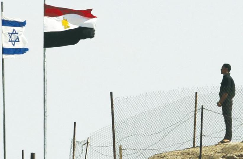 EGYPTIAN AND ISRAELI flags flutter next to each other at the Taba border crossing. (photo credit: REUTERS)