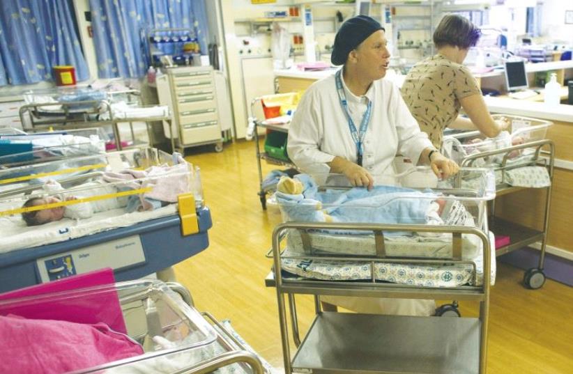 NURSES TAKE CARE of newborn infants at a nursery in Hadassah-University Medical Center in Jerusalem’s Ein Kerem. (photo credit: REUTERS)