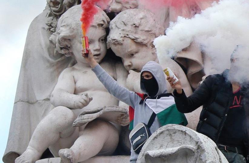 Protesters climb on the statue in the Place de la République in Paris during a banned demonstration in support of Gaza on July 26, 2014 (photo credit: BENOIT TESSIER /REUTERS)