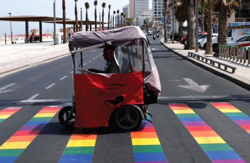 A SIDEWALK painted with colors for the gay pride parade in Tel Aviv. The author wonders why anti-Israel Jewish academics don’t support Israel’s gay rights and liberal values? (photo credit: REUTERS)