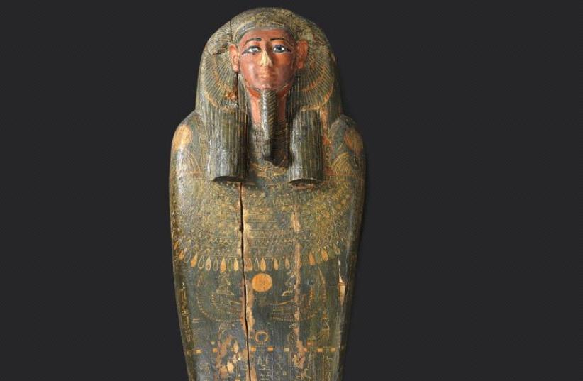 The lid of the mummy’s coffin sports characteristic ancient Egyptian stylized facial features and informative hieroglyphics (photo credit: ELIE POSNER)