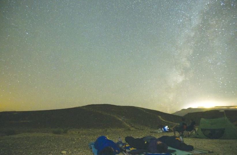 PEOPLE SLEEP through the annual Perseid meteor shower in the Ramon Crater last August. (photo credit: REUTERS)